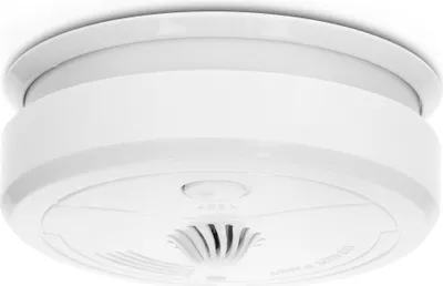 A white smoke detector is mounted on a white ceiling.