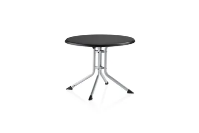 A round, black-topped table with a silver, folding base, photographed against a white background.