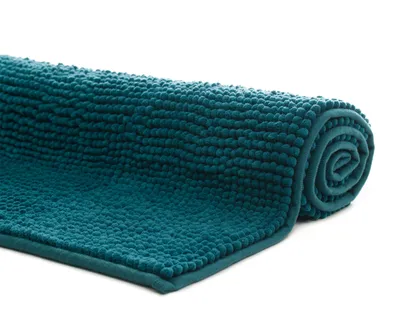 A rolled-up teal chenille bath mat on a white background.