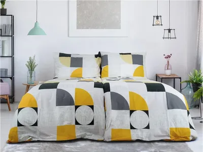 A neatly made bed with geometric patterned bedding in a bright room.