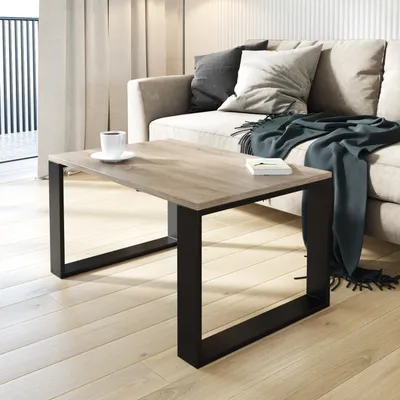 A coffee table with a cup of coffee and a book on it, placed in a living room setting with a sofa and curtains.