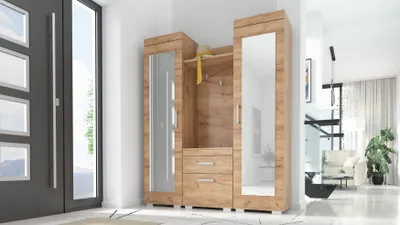A hallway with a modern wooden wardrobe featuring mirrors and drawers, next to a dark gray door.