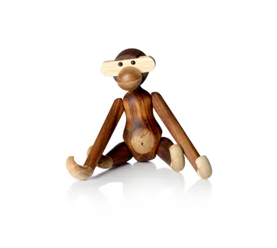 A wooden monkey toy is sitting on a white background.