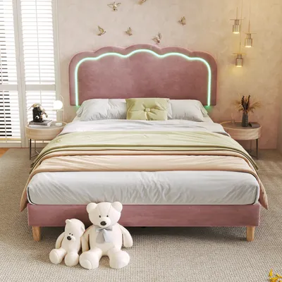 A pink upholstered bed with a scalloped headboard and integrated LED lighting, set in a bedroom with decorative birds on the wall and bedside tables.