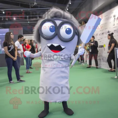 Obrázok produktu pre Postava maskota REDBROKOLY: sivý robot s nožmi, oblečený v ceruzkovej sukni a s okuliarmi