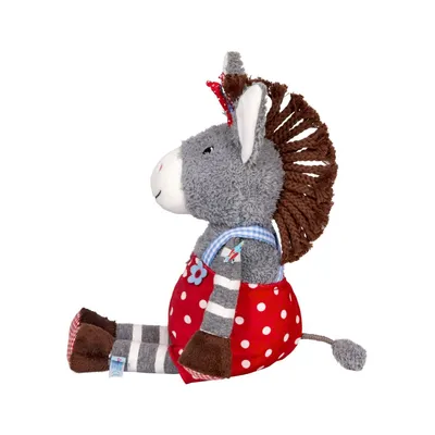 A stuffed donkey toy sitting down, viewed from the side.
