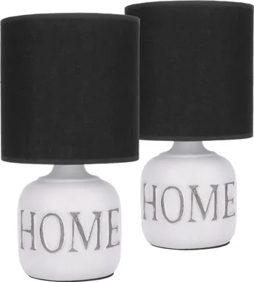 Two identical table lamps with black fabric shades and white ceramic bases featuring the word 'HOME' in gray.