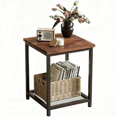 A square side table with a wooden top and metal frame, decorated with a vase of flowers, a small radio, and a candle on top, and a basket of books on the lower shelf.