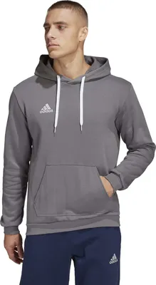 A man wearing an Adidas hoodie and navy sweatpants.