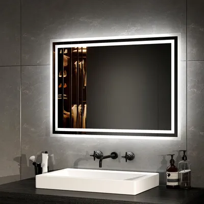 A modern bathroom vanity with a sink and a lighted mirror.