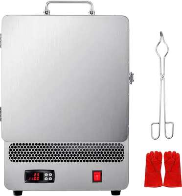A silver electric melting furnace with a digital display and red power button, along with a pair of metal tongs and red heat-resistant gloves, is presented against a white background.