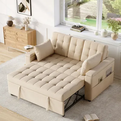 A beige sofa bed is shown in a living room setting with a window and a dresser in the background.