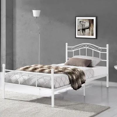 A white metal bed frame in a bedroom setting.