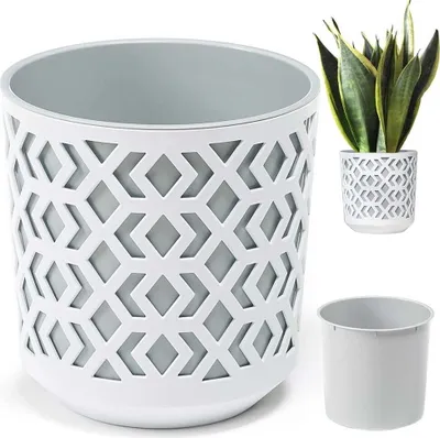 A white planter with a geometric cut-out pattern and a grey inner pot, shown with a smaller planter containing a snake plant and a separate inner pot.