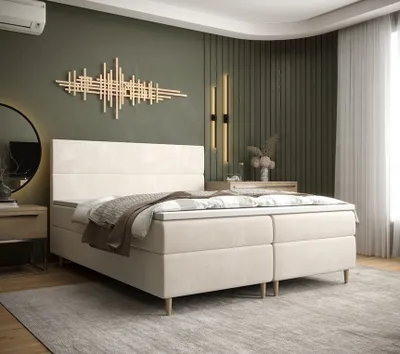 A bedroom scene featuring a beige boxspring bed.