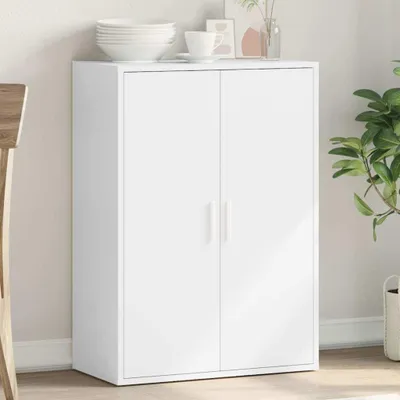 A white sideboard with two doors is shown in a room setting, with some decorative items on top and a plant nearby.