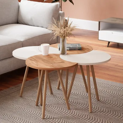 A set of nesting coffee tables in a living room setting, next to a sofa.