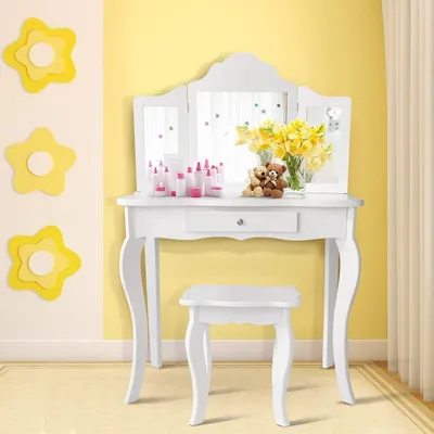 A white vanity table and stool set with a tri-fold mirror, decorated with yellow flower cutouts on a yellow wall.