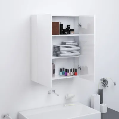 A white medicine cabinet with its door open, displaying shelves with toiletries, towels, and nail polish, mounted on a white wall above a white sink.