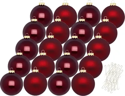 A collection of red Christmas ornaments with gold caps, arranged in rows, with a pile of gold ornament hooks in the lower right corner.