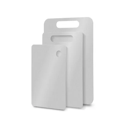 Three white cutting boards of different sizes are stacked and shown from the side against a white background.