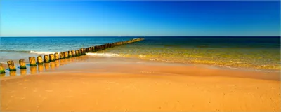 Produktbild von Wallario Poster - Sandstrand in orange - Blaues Meer - Blauer Himmel, Kunstdruck Größe: 80 x 200 cm