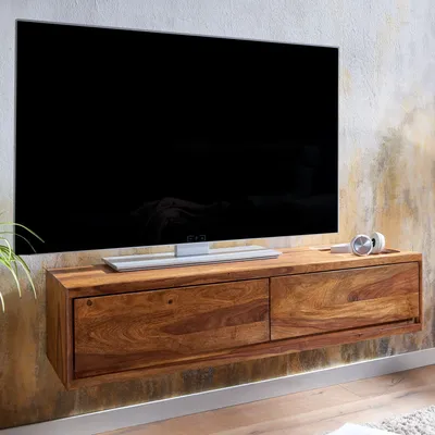 A modern, wall-mounted wooden TV stand with two drawers, holding a large flat-screen television.