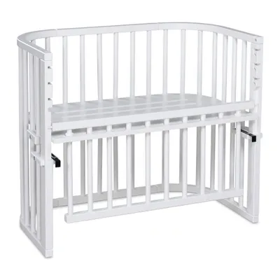 A white baby crib with a mattress.