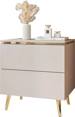 A beige nightstand with gold accents and legs, decorated with a vase of dried flowers and two perfume bottles.
