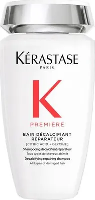 A white bottle of Kerastase shampoo with silver accents on the cap.