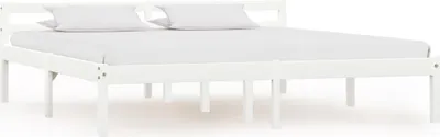 A white wooden bed frame with two white pillows and a white mattress.