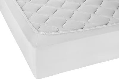 A close-up view of a white mattress protector with a quilted top and elasticized edges.