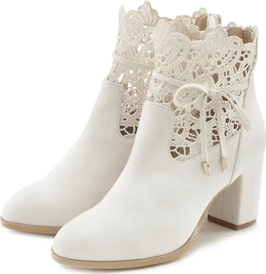 A pair of beige high-heeled ankle boots with lace detailing.
