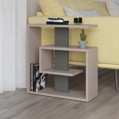 A modern side table with books and a plant next to a yellow sofa.