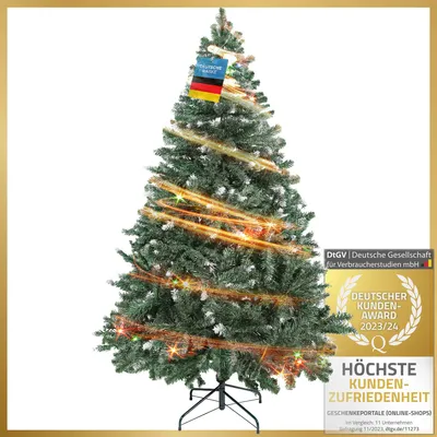 A decorated artificial Christmas tree with a German flag on top and a quality award badge on the side.