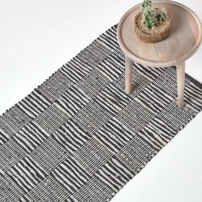 Produktbild von HOMESCAPES Schwarz-Weißer handgewebter Lederteppich mit quadratischem Muster, 66 x 200 cm