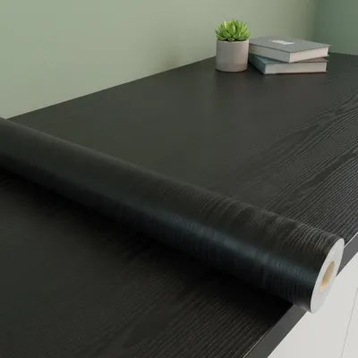 Produktbild von Schutzklebefolie auf Rolle mit schwarzer Holzoptik, Meterware – Selbstklebende Abdeckung für Küche, Möbel und Bad – 60 cm x 50 m