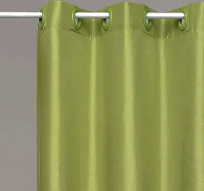 A close-up of a green curtain with grommets hanging from a rod.