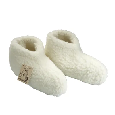 A pair of white, fluffy slippers shown from a slightly elevated side angle against a white background.
