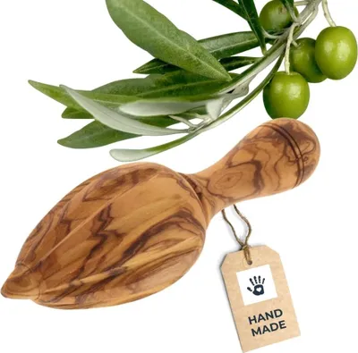 A wooden olive oil press and a branch with olives on a white background.