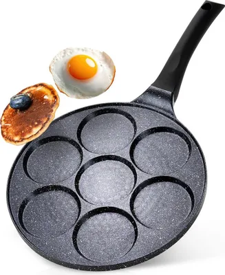 A multi-cup frying pan with a pancake and a fried egg on a white background.
