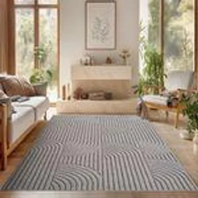 A living room with a sofa, fireplace, and a rug.