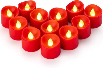 A collection of red LED tea lights arranged in a heart shape on a white background.