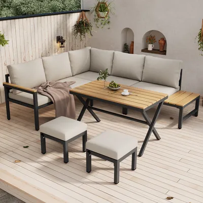 An outdoor patio setting with a sectional sofa, coffee table, and ottomans.