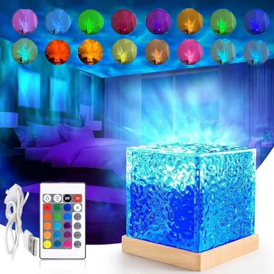 A bedroom scene with a projector light creating a starry sky and water wave effect on the ceiling and walls. A cube-shaped lamp with a wooden base is in the foreground, along with a remote control and USB cable.