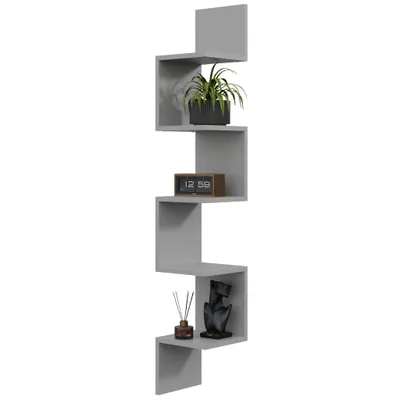 A grey zigzag corner shelf mounted on a white background, decorated with a potted plant, a digital clock, and a decorative bust with reeds.