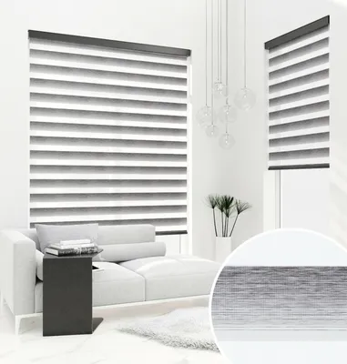 A modern living room with a chaise lounge and a large window covered by blinds.