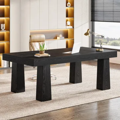 A modern office setting with a black desk, laptop, and a desk lamp.
