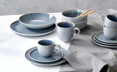 A collection of stoneware dishes and mugs arranged on a table.