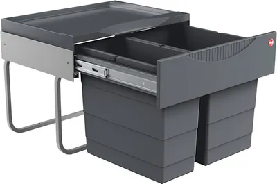 A dark gray kitchen waste bin system with two compartments, shown with one drawer pulled out.